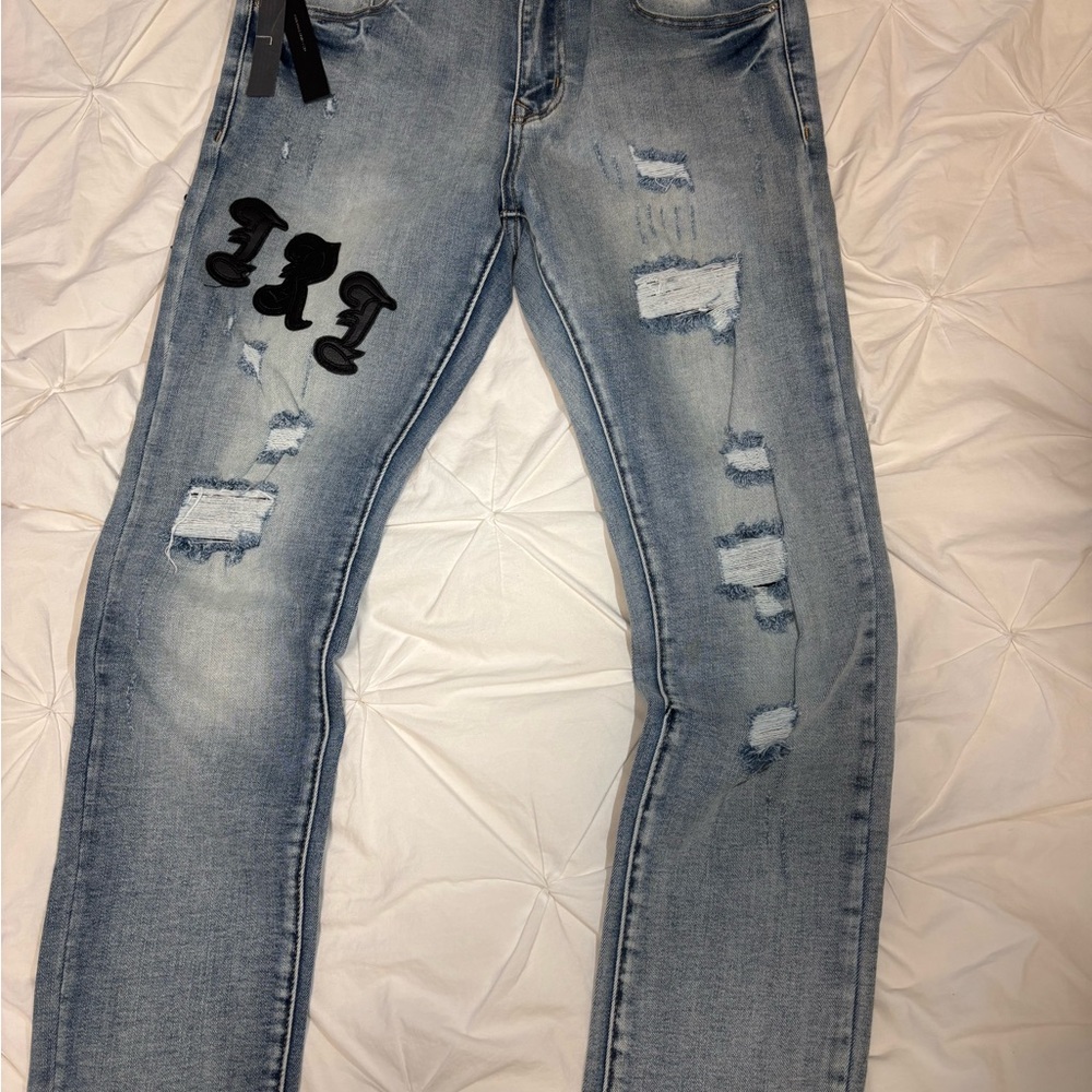 Distressed Light Blue Jeans with Black Patch